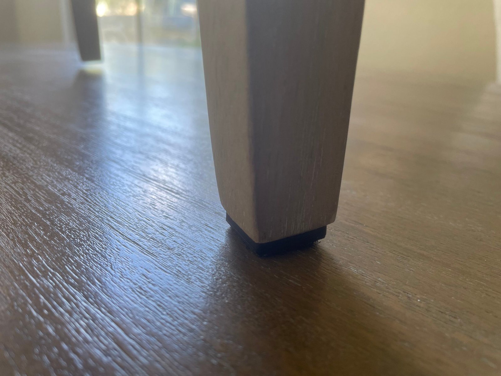 Square nail-on glides on a wooden dining chair, hardwood floor