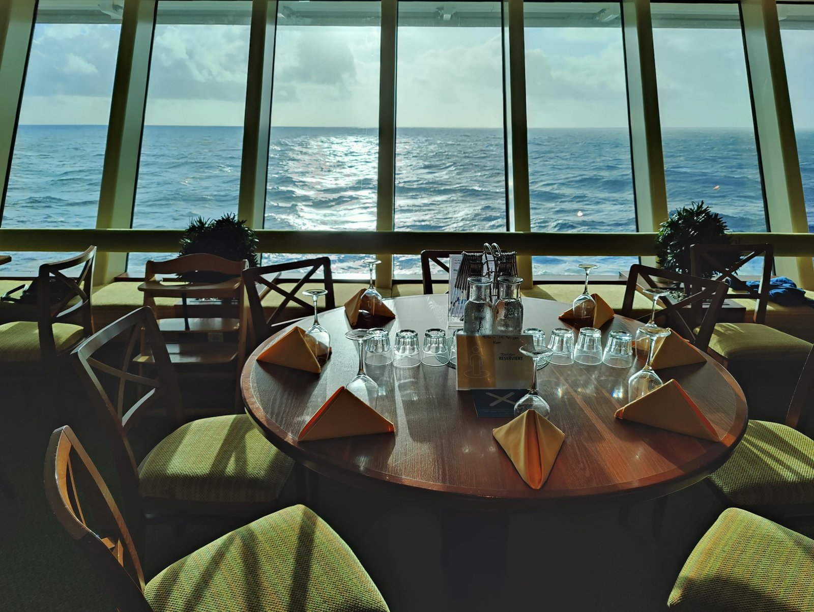 Cruise ship restaurant tables and chairs by a window over the sea