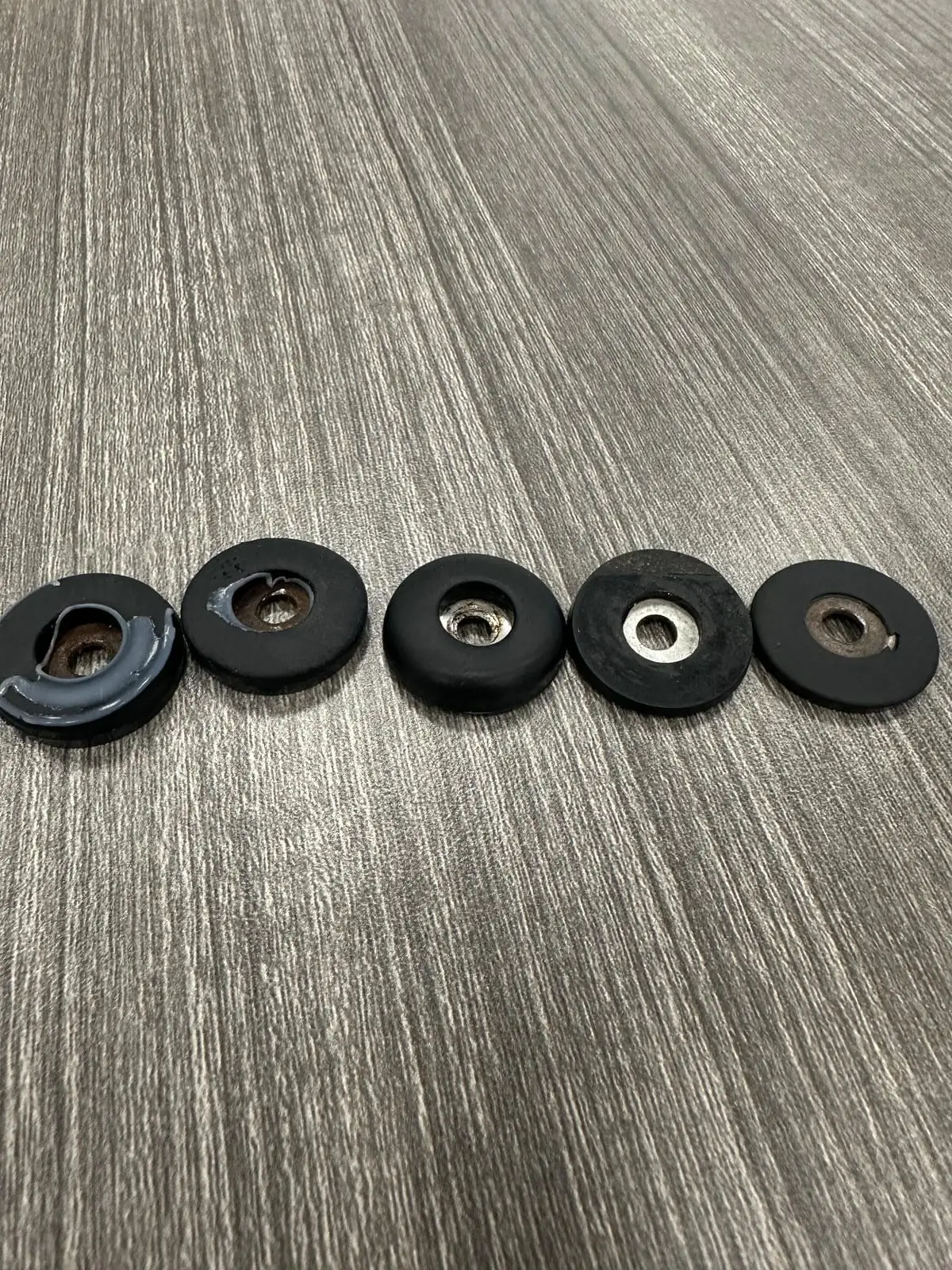 Five worn PTFE glides removed from restaurant dining chairs