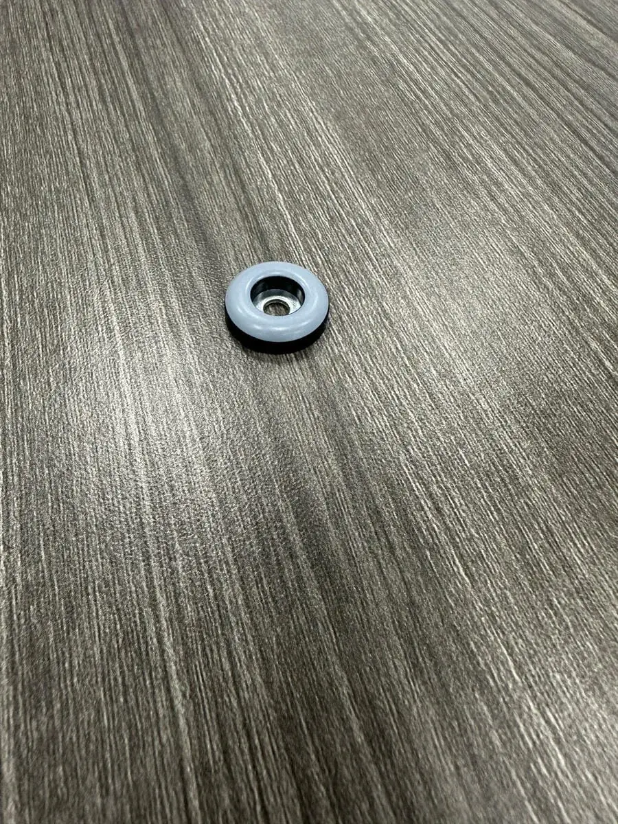 A single worn PTFE glide still on a restaurant chair leg